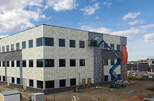 vapour barrier and inulation being applied as part of a building's exterior wall construction 