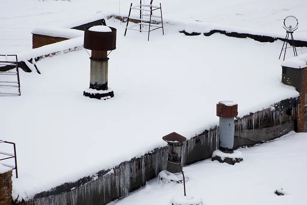 snow and ice buildup on commercial flat roof