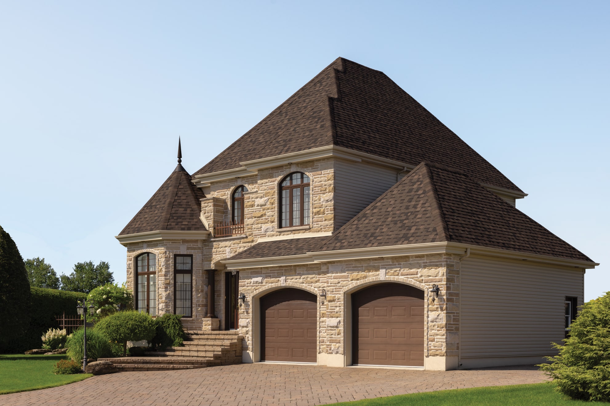 This two-story brick house showcases a touch of dynasty with its elegant white siding, black shutters, and shingled roof. The striking red front door and bay window invite you into a beautifully landscaped front yard.