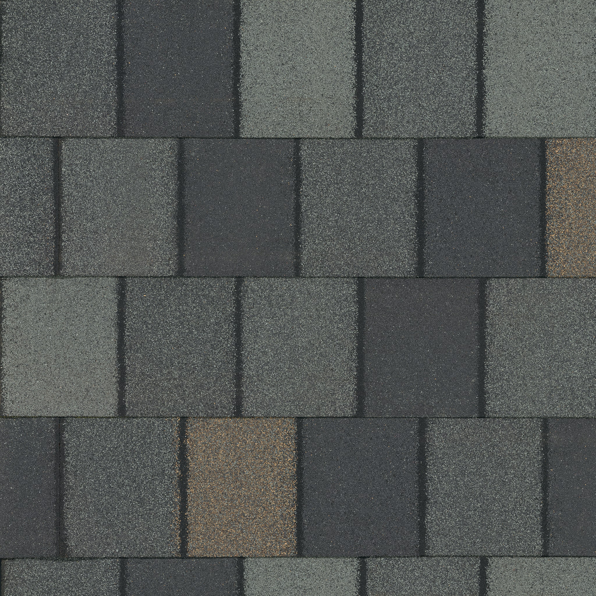 Close-up of Crowne Slate asphalt shingles with a dark green, rectangular pattern. Some shingles reveal a brownish tint.