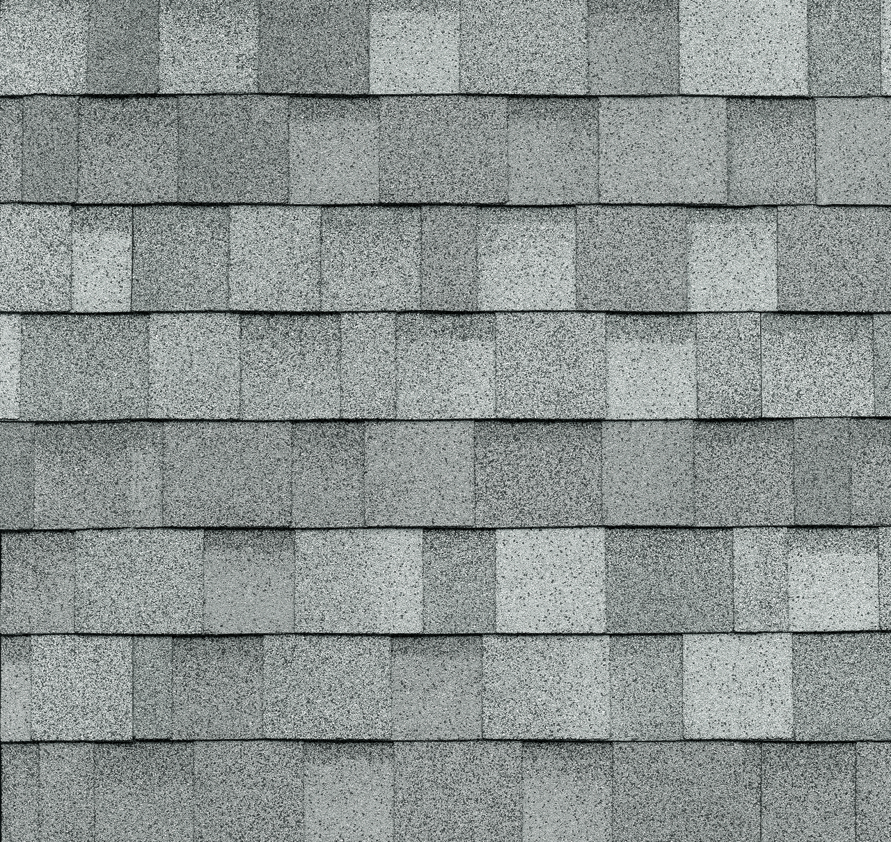 A close-up of Frostone Grey asphalt shingles arranged in a uniform pattern on a roof captures the timeless elegance of the Dynasty collection.