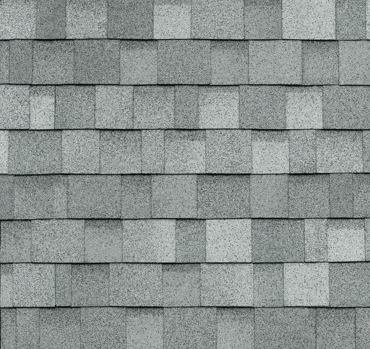 A close-up of Frostone Grey asphalt shingles arranged in a uniform pattern on a roof captures the timeless elegance of the Dynasty collection.