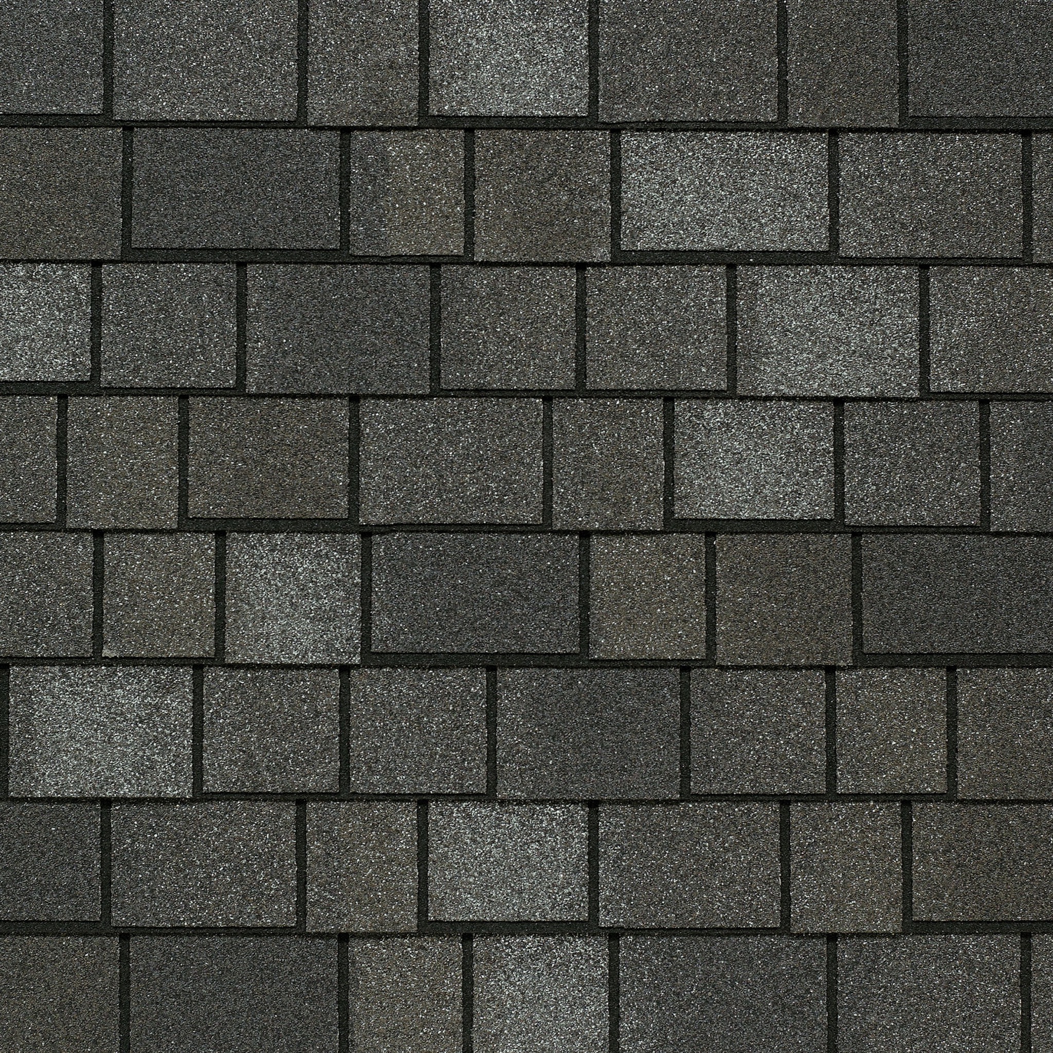 Close-up of a dark gray asphalt shingle roof with a pattern reminiscent of Royal Estate elegance, where rectangular shingles vary slightly in shade, echoing the timeless allure of Mountain Slate.