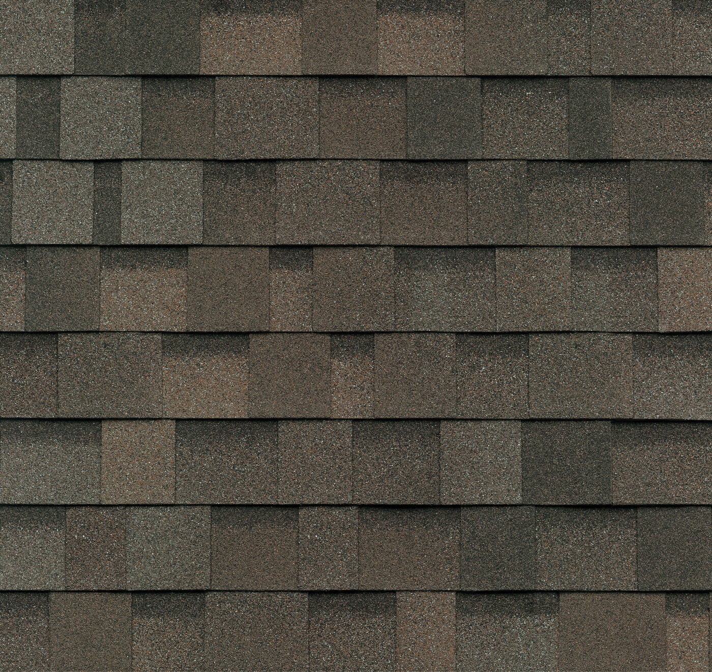 Close-up view of a roof with overlapping asphalt shingles in shades of gray and brown, creating a textured pattern reminiscent of Dynasty architecture.