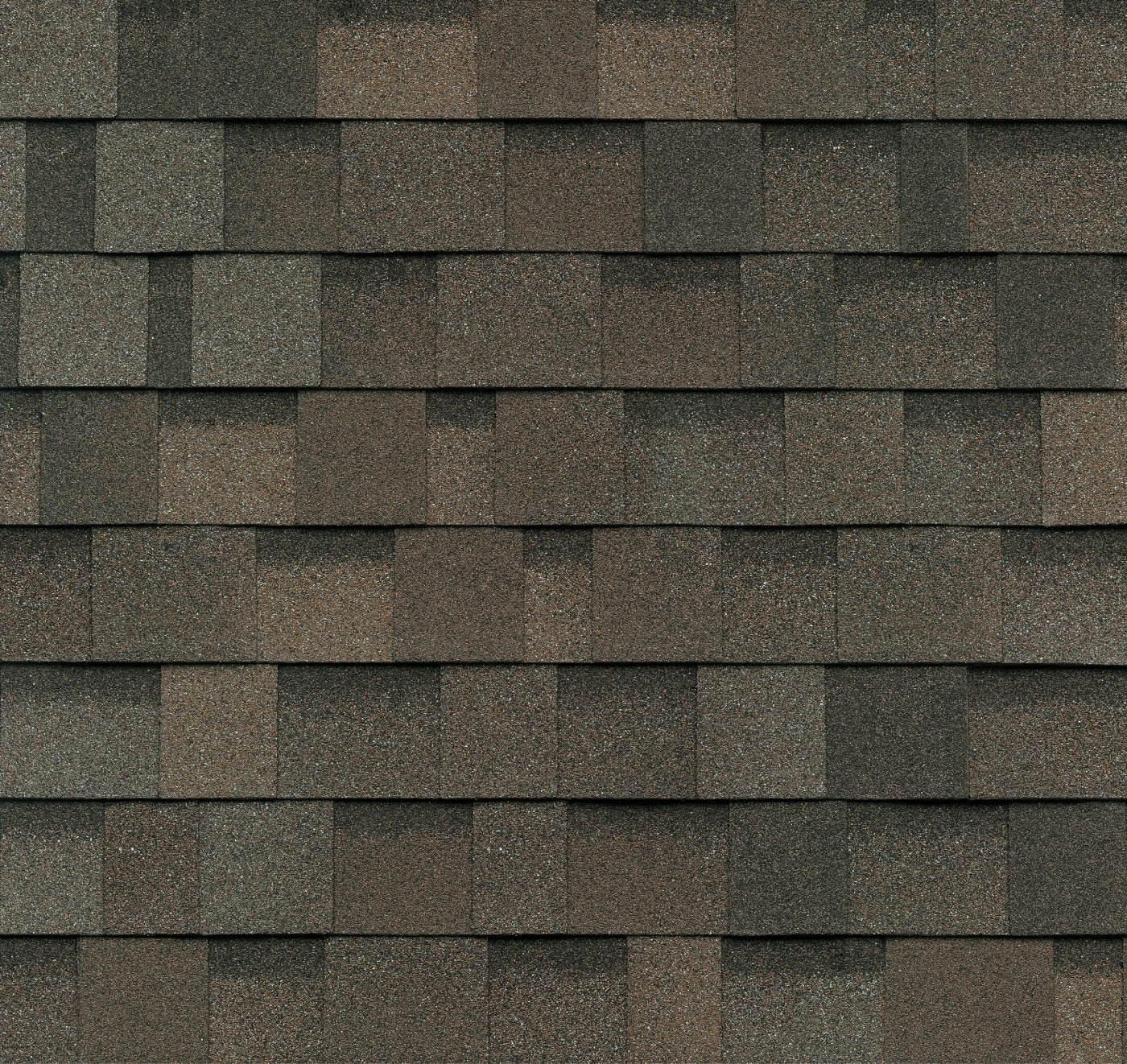 Close-up of a roof showcasing Nordic charm with overlapping brown asphalt shingles arranged in a repetitive pattern, evoking a sense of driftshake elegance.