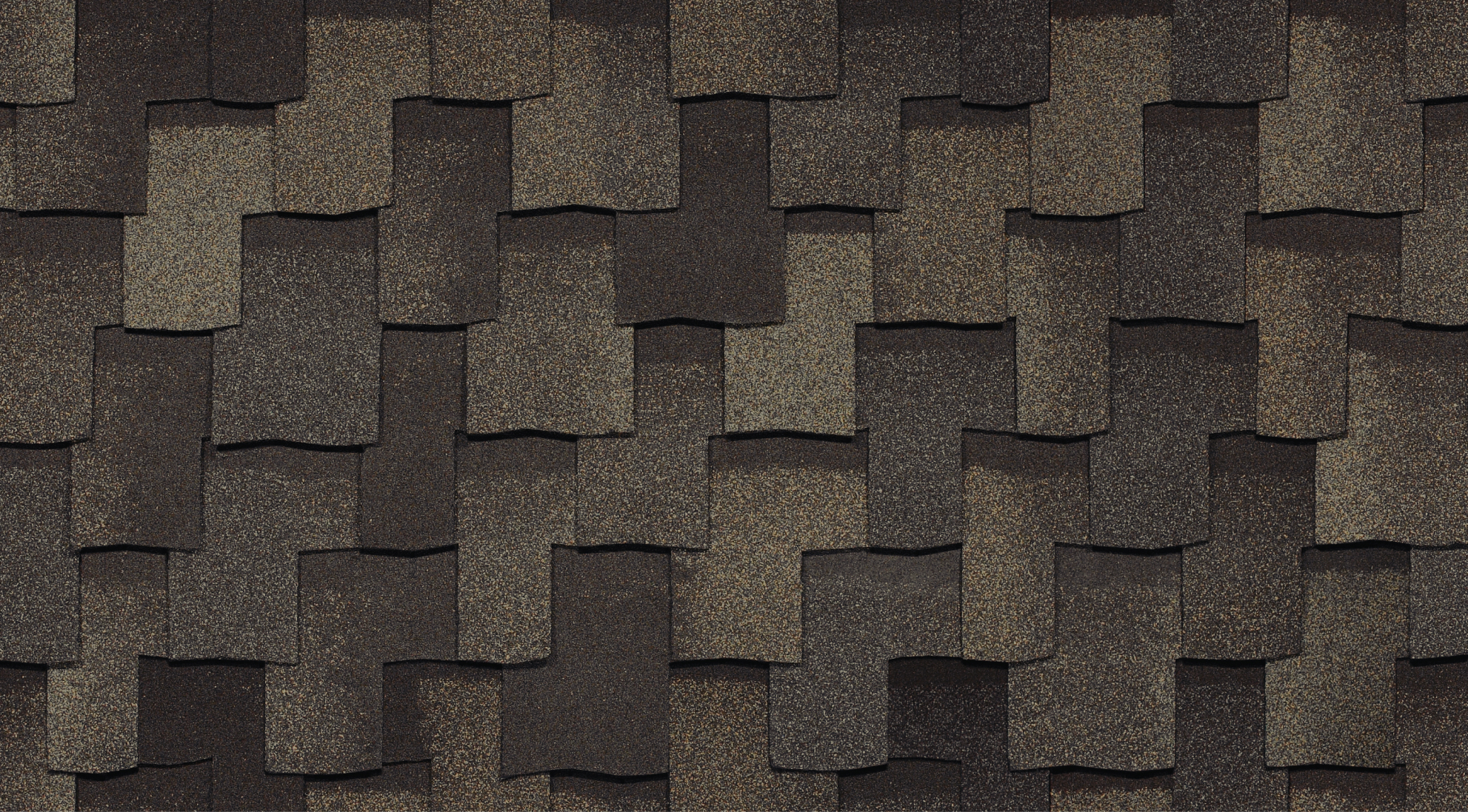 The close-up captures the textured Armourshake asphalt shingles in various shades of brown and gray, resembling weathered stone, arranged in an overlapping pattern.