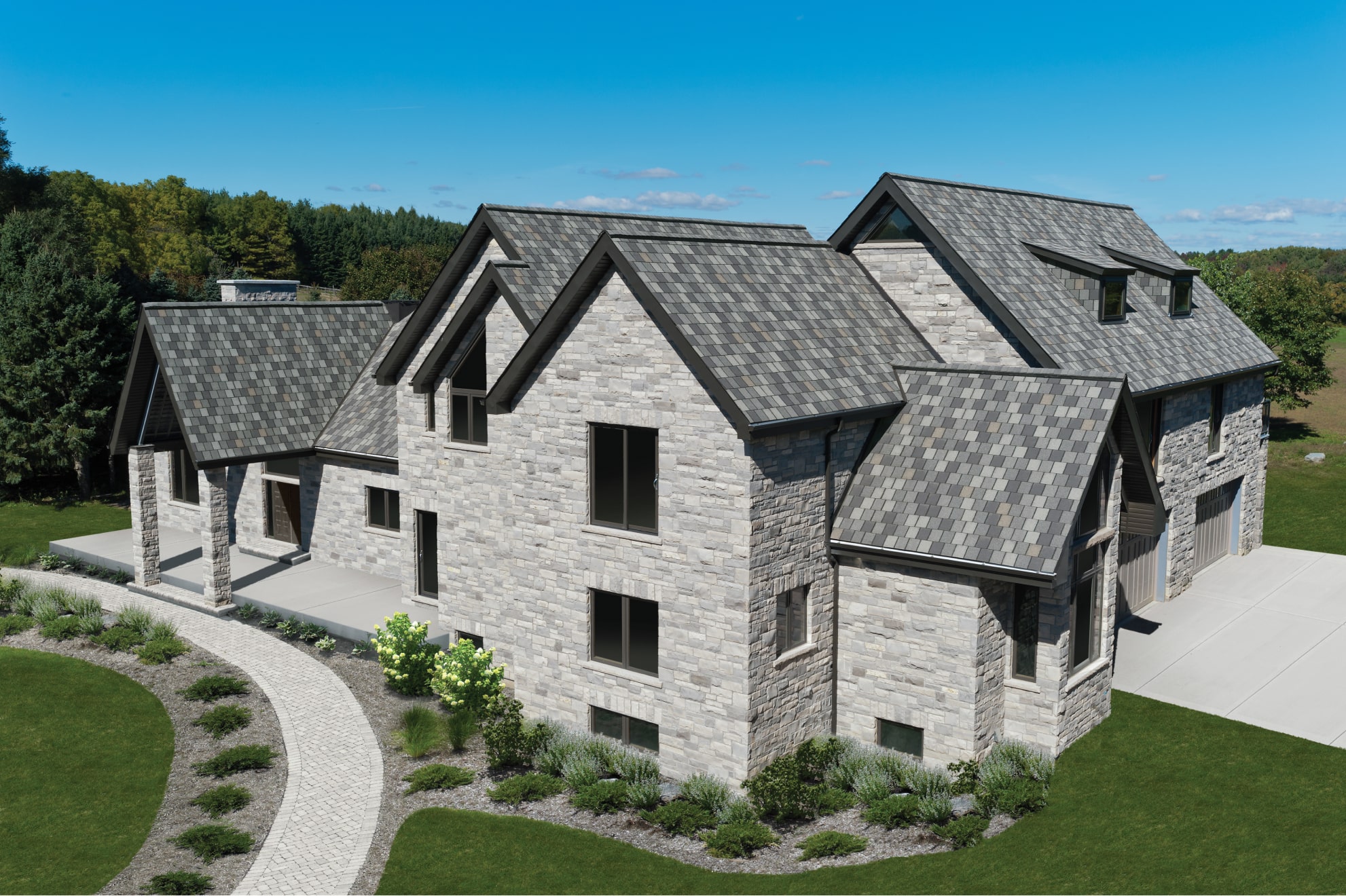 This stone house, featuring Crowne Slate roofs, is surrounded by a lush green lawn and trees. A curved walkway adds to the charm as it leads to the entrance.