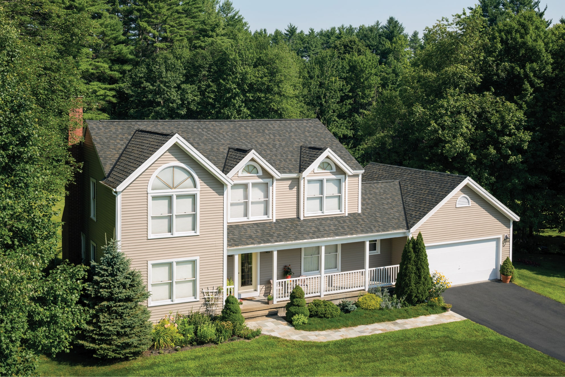 This two-story brick house showcases a touch of dynasty with its elegant white siding, black shutters, and shingled roof. The striking red front door and bay window invite you into a beautifully landscaped front yard.