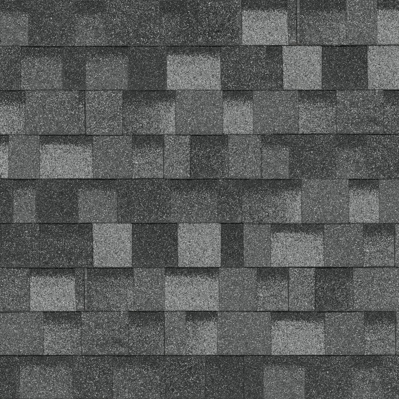 A close-up view of a roof covered with Summit Grey asphalt shingles, arranged in a Nordic-inspired staggered pattern.