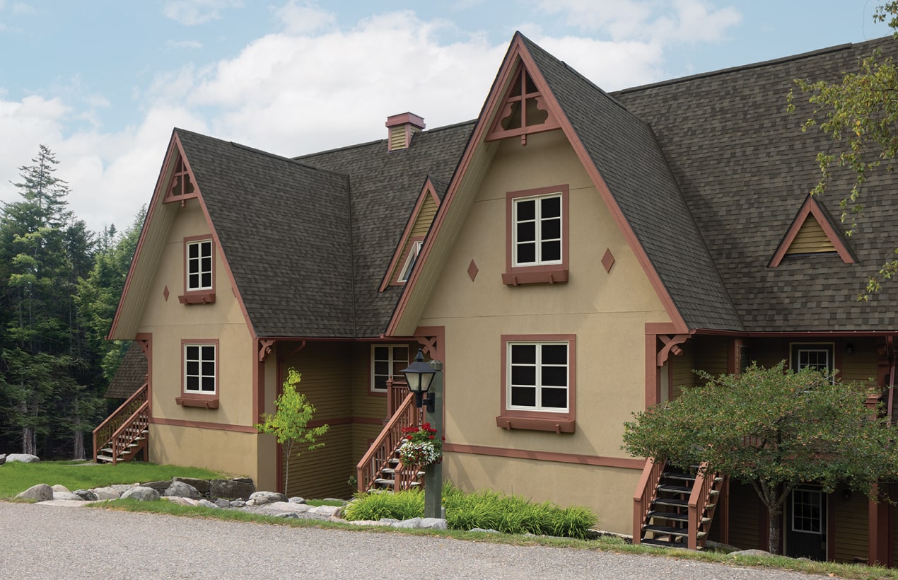 This two-story brick house showcases a touch of dynasty with its elegant white siding, black shutters, and shingled roof. The striking red front door and bay window invite you into a beautifully landscaped front yard.