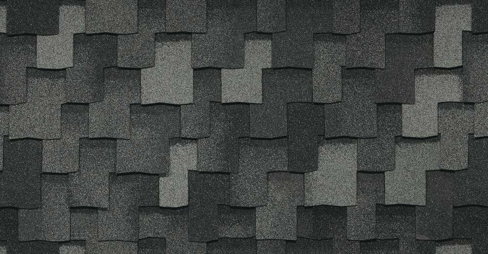 Close-up view of overlapping dark gray Armourshake asphalt roof shingles with a textured surface, showcasing the premium quality of Greystone roofing.