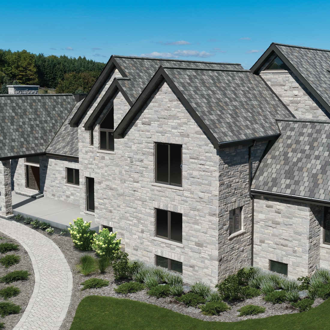 Nordic-style stone house with multiple gabled roofs, surrounded by lush grass and a curved pathway. The exterior showcases gray brickwork and several windows beneath a clear blue sky.