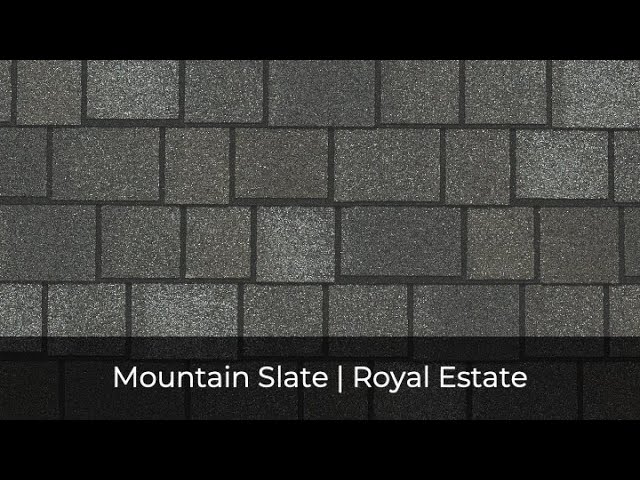 Roof shingles exhibit a stunning pattern of dark and light gray squares, famously known as "Mountain Slate" from the IKO Roof Shingle Colors collection. Labeled under the "Royal Estate" line, they promise both durability and an exquisite architectural touch.