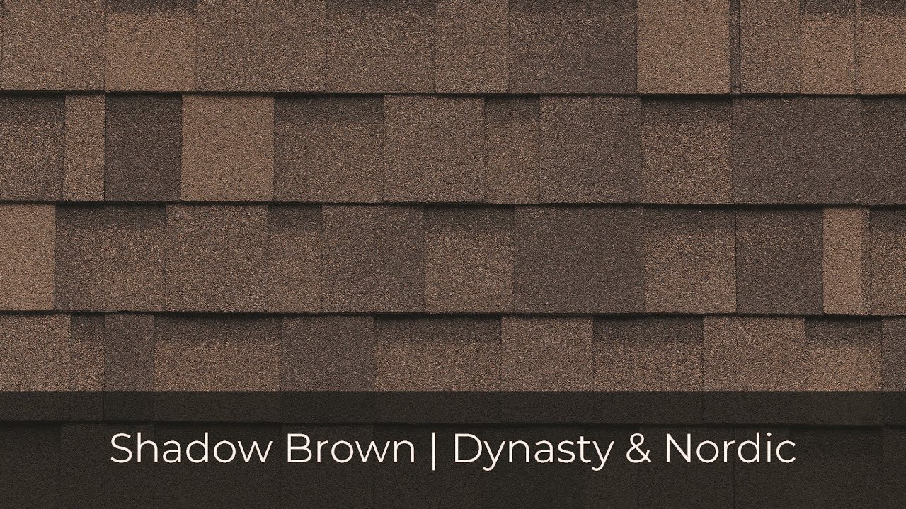 Close-up of a brown shingle roof with a text overlay at the bottom: "Shadow Brown | Dynasty & Nordic," showcasing the superior roof performance of IKO Roof Shingle Colors.