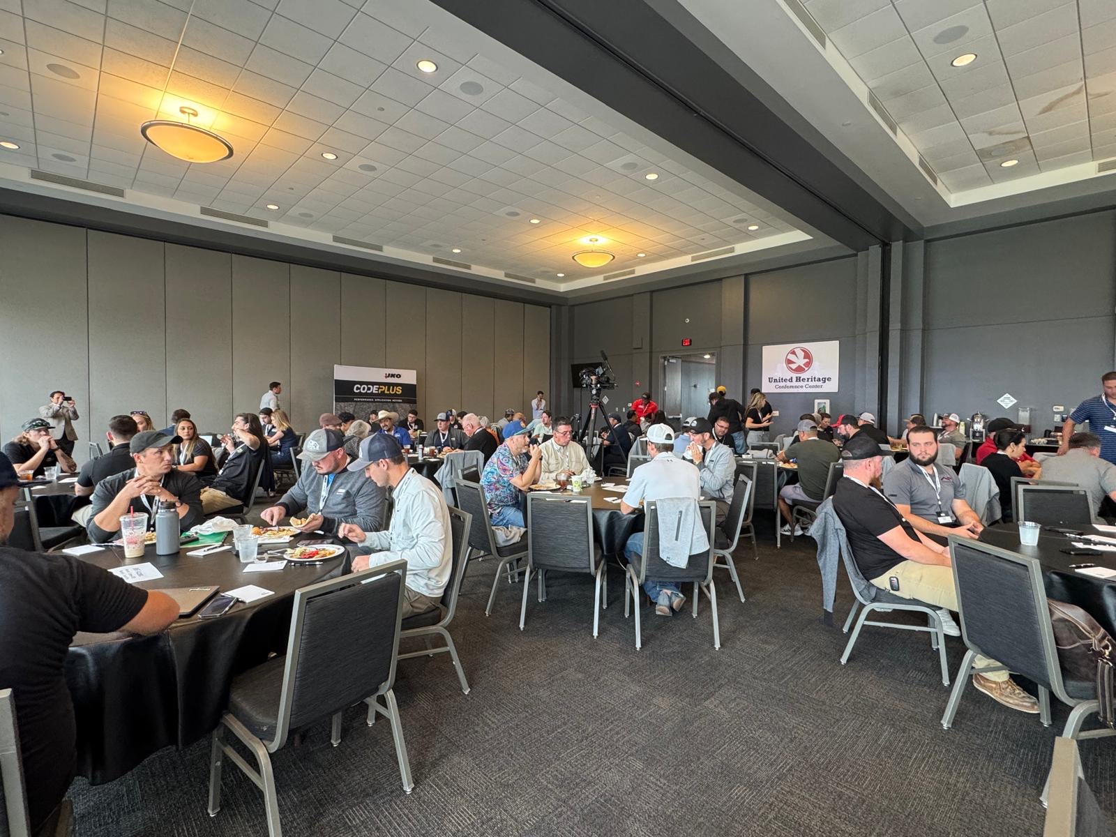 People seated around tables in a conference room, engaged in discussions during the Profit Power Events. Banners of IKO and ROOFPROs are visible on the walls, highlighting their sponsorship.