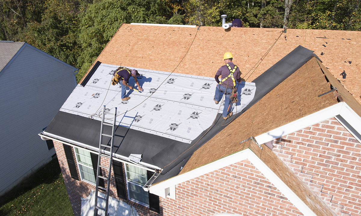 two roofers intalling roof underlayment
